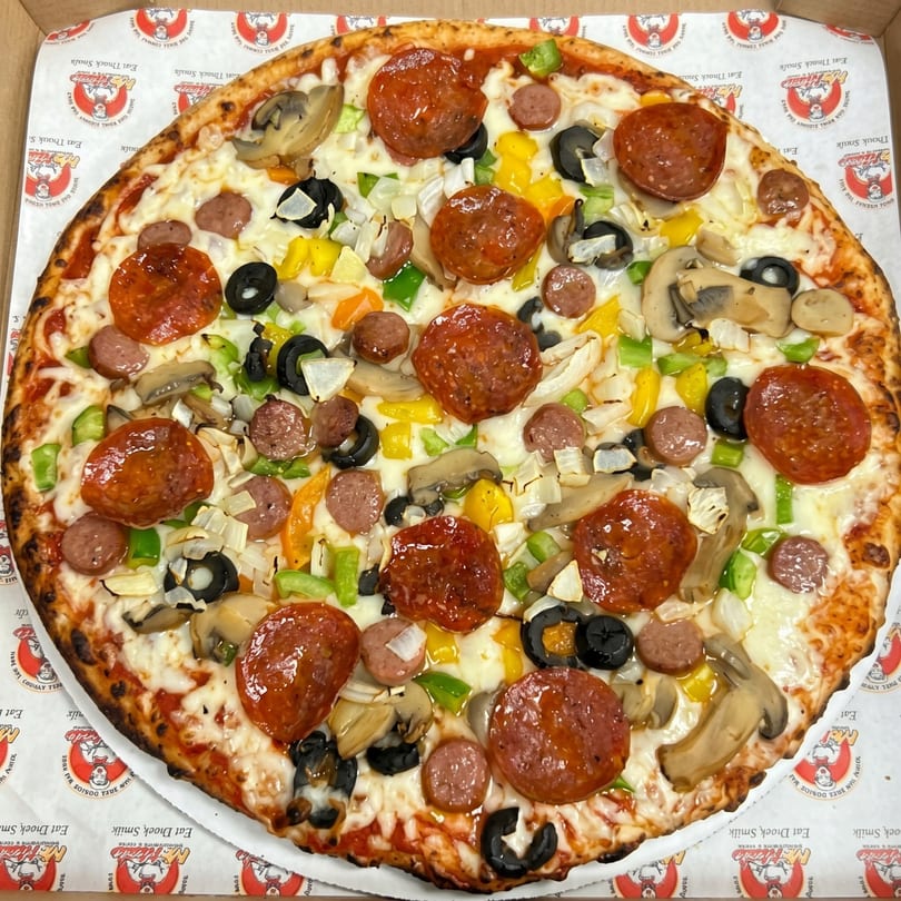A large, fully loaded pizza with pepperoni, sausage, mushrooms, olives, onions, and bell peppers.